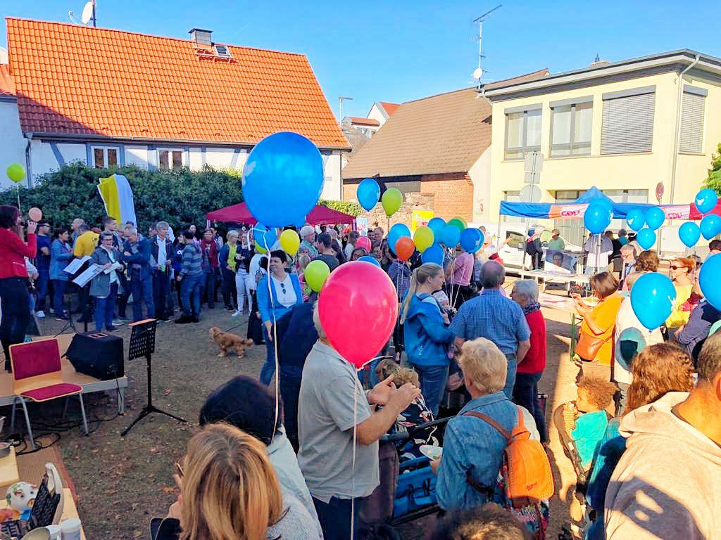 Viele Menschen auf dem Egelsbacher Marktplatz, auffalend viele bunte Luftballons und strahlendes Wetter